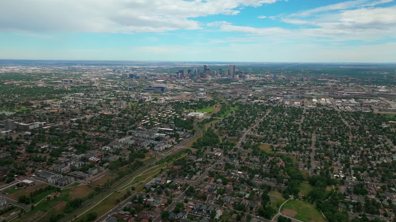 Summer downtown Denver Colorado aerial drone cloudy front range foothills landscape 6th avenue colfax RTD line Mile High city skyscrapers neighborhood homes blue skies clouds forward pan reveal motion