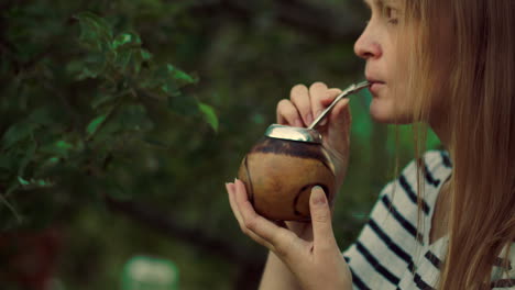 young woman drinking mate outdoor