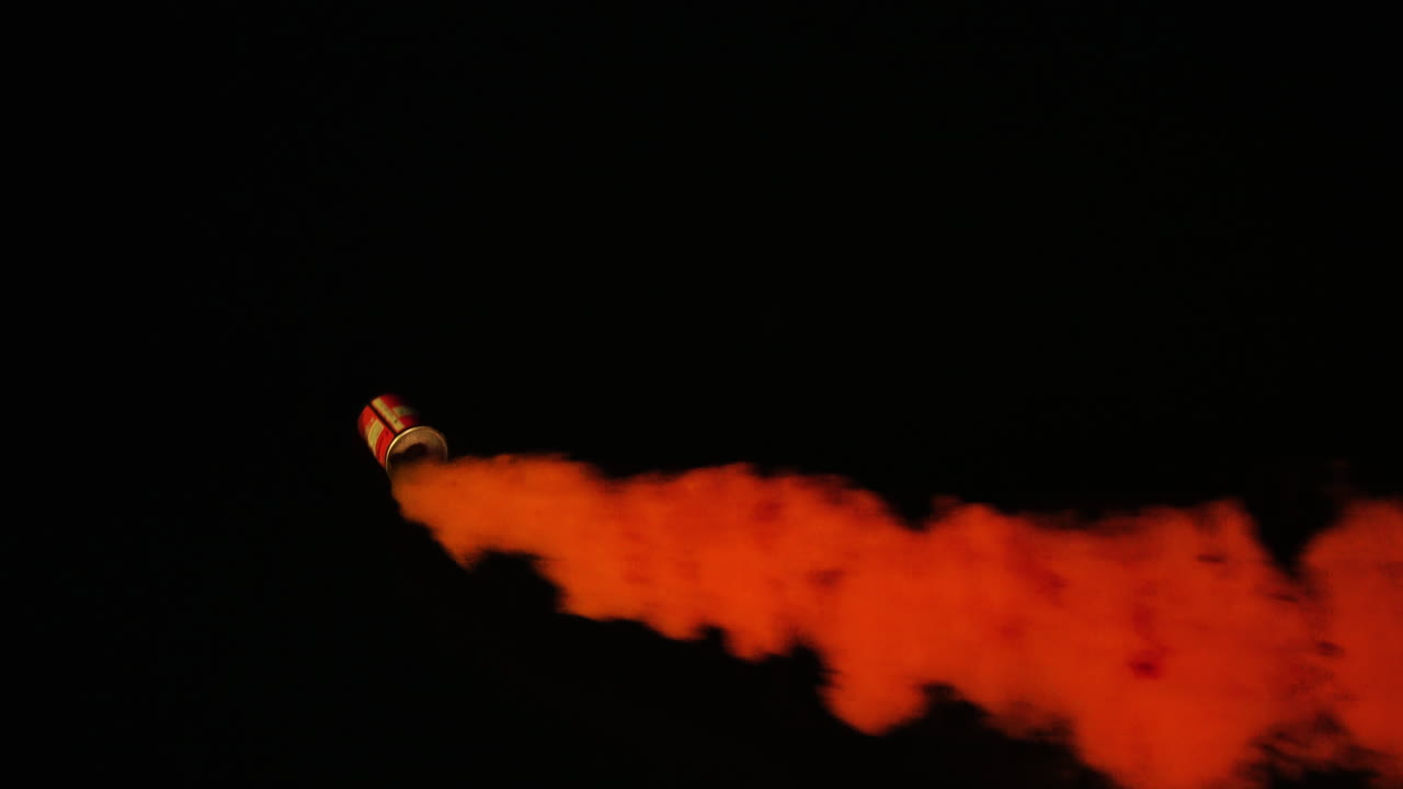 黒の背景に円運動で移動するオレンジ色の海洋緊急煙フレア