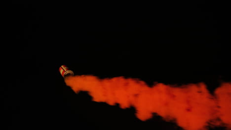 Orange-marine-emergency-smoke-flare-moving-in-circular-motion-with-black-background