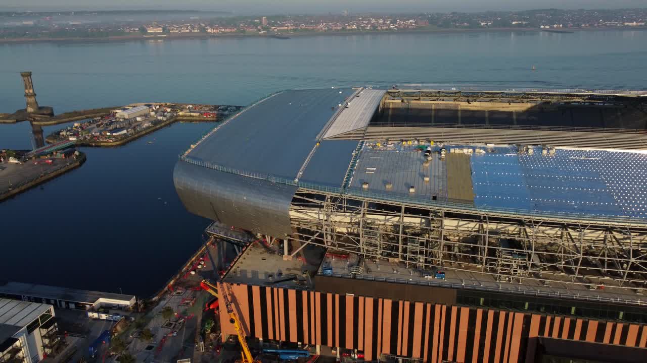 Aerial view of a large sports stadium under construction by a river