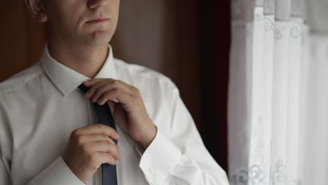 Handsome-groom-fixes-his-tie.-Wedding-morning.-Businessman.-Slow-motion