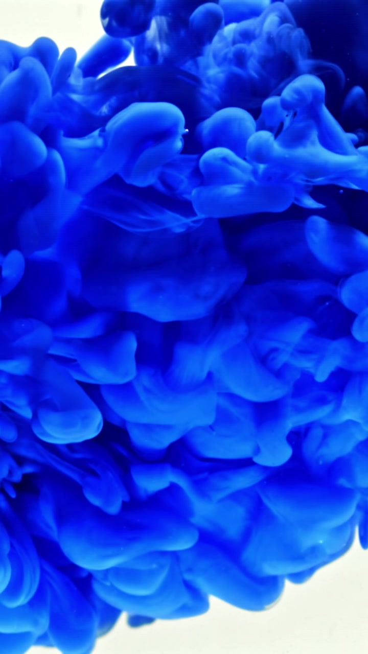 Inchiostro blu vibrante che si diffonde e si dissolve nell'acqua