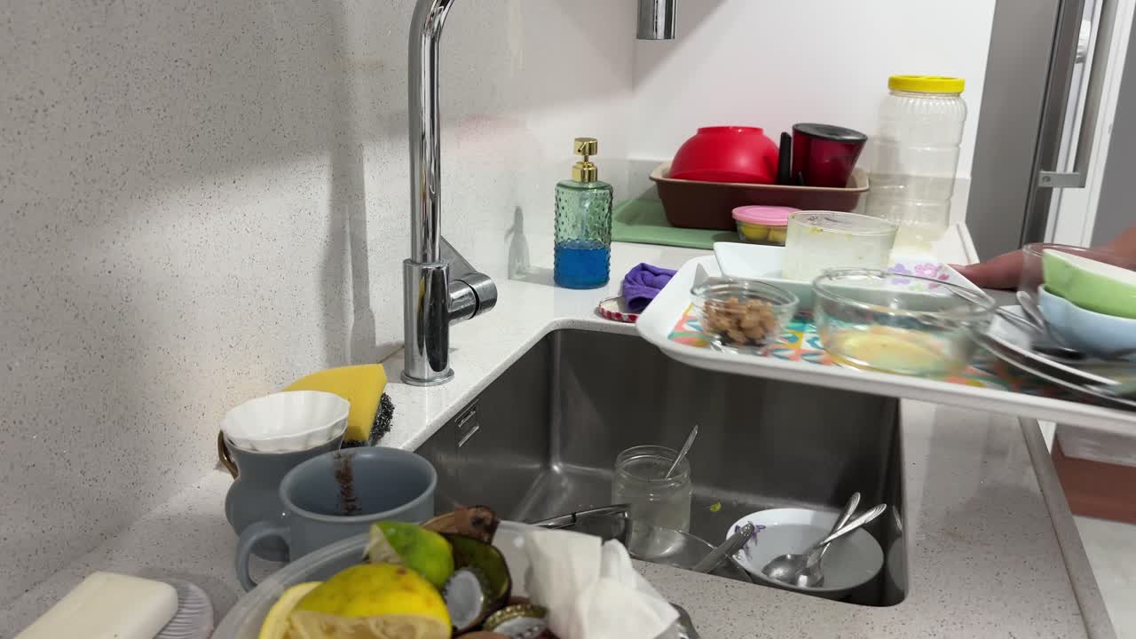 Close-up of dirty dishes and cutting board beside sink, depicting everyday household kitchen environment