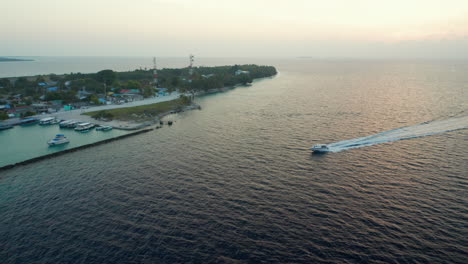 Sunset-on-Dharavandhoo-Island-with-a-speedboat-crossing-in-the-Maldives