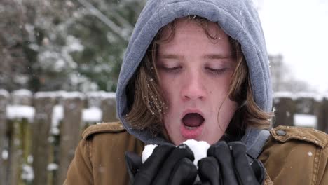 a guy blows a handful of snow at the camera