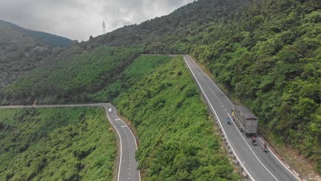 Flying-above-the-Hai-van-pass-Vietnam-busy-road,-aerial