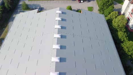 flying over a large sports hall covered with insulation panels and plastic light domes