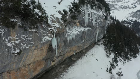 jib down of melting icicle on the edge of mountain