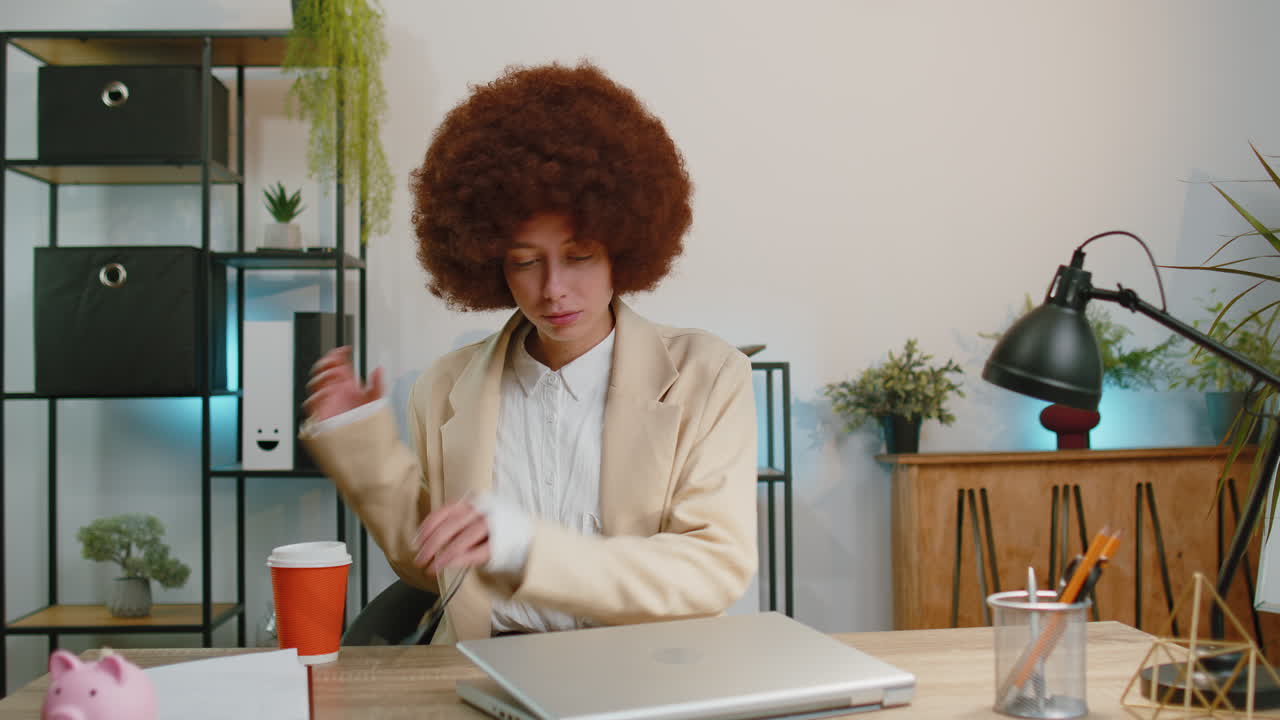 Businesswoman enters office start working on laptop computer at desk and drinking morning coffee