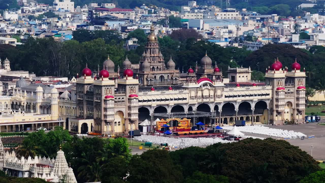Nærbillede af Mysuru Paladset med forgyldt kuppel, tempel og beboelsesbygninger i Mysore, Karnataka, Indien. Dagtid, tilbagetrækningsoptagelse, droneoptagelse, 4K.
