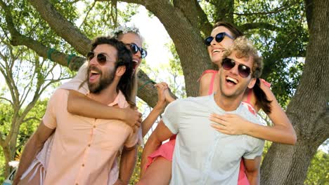 hipster boys carrying girls on their shoulder