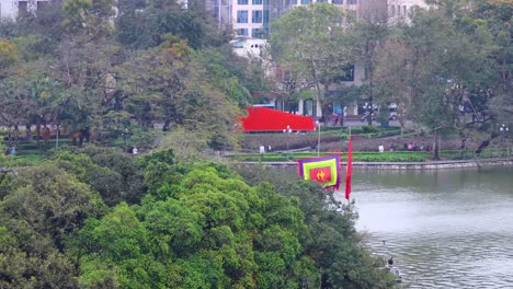 colorful kite flying above lush green trees