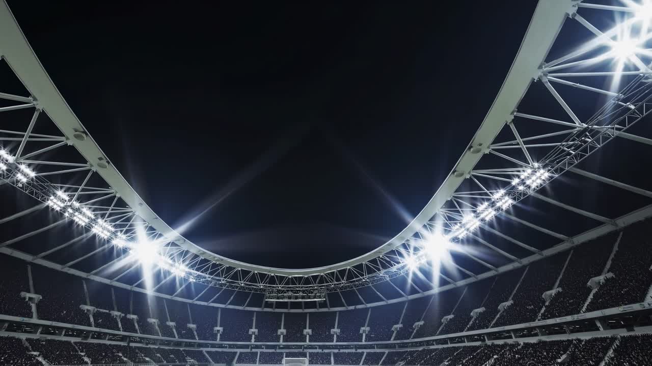 Powerful stadium lights illuminating the playing field at night, creating a dramatic atmosphere filled with energy as the crowd cheers, eagerly anticipating the thrilling game ahead