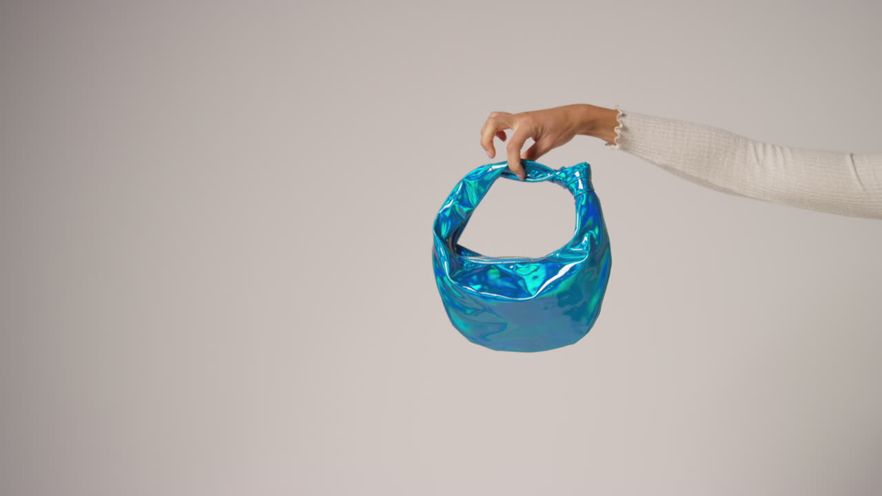 블루 패션 드백을 들고 사용자 생성 콘텐츠를 생산하는 여성 소셜 미디어 인플루언서의 클로즈업