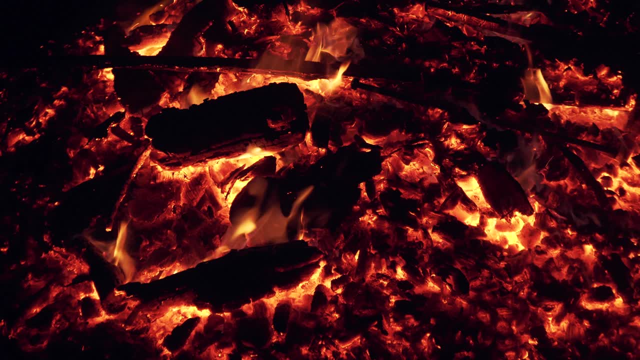 red embers of a big campfire with a flame
