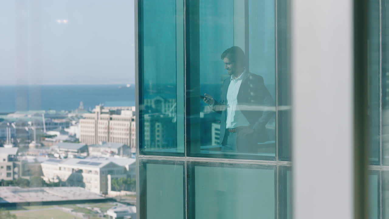 hombre de negocios exitoso que usa un teléfono inteligente haciendo una llamada telefónica discutiendo negocios mirando por la ventana ejecutivo corporativo charlando por teléfono móvil administrando la compañía 4k