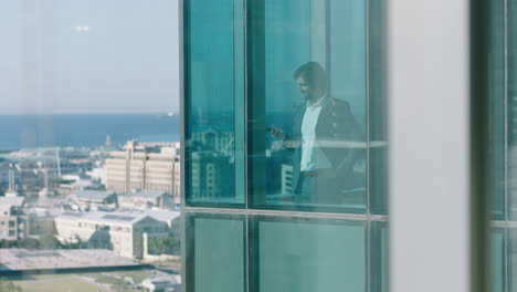 successful businessman using smartphone making phone call discussing business looking out window corporate executive chatting on mobile phone managing company 4k