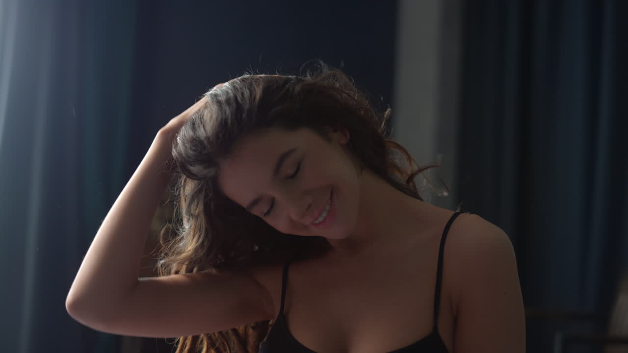 mujer feliz con la cabeza giratoria y el cabello ondulado