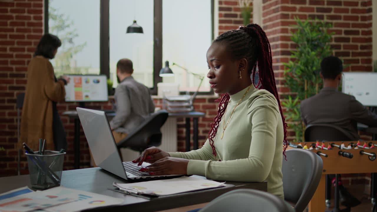 African american woman working on laptop in business office
