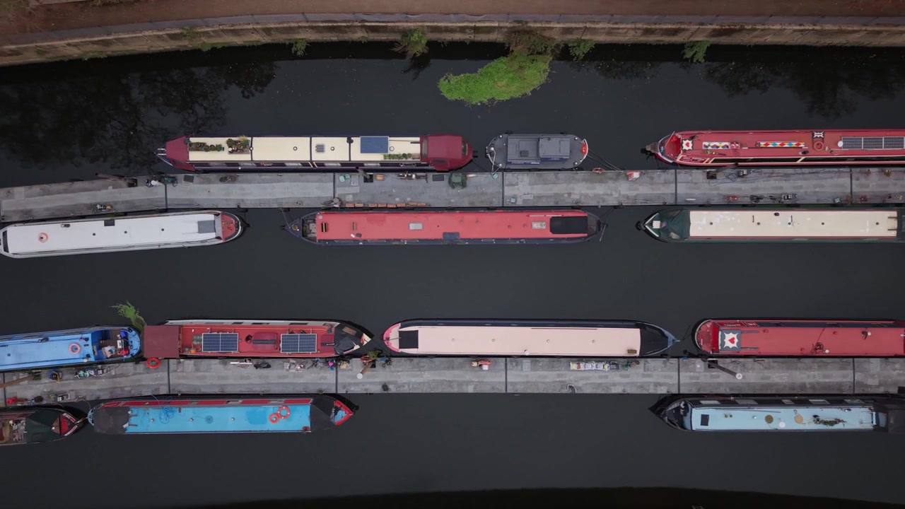 Luftaufnahme von Narrowboats, die im Herbst auf einem Kanal in England festgemacht sind