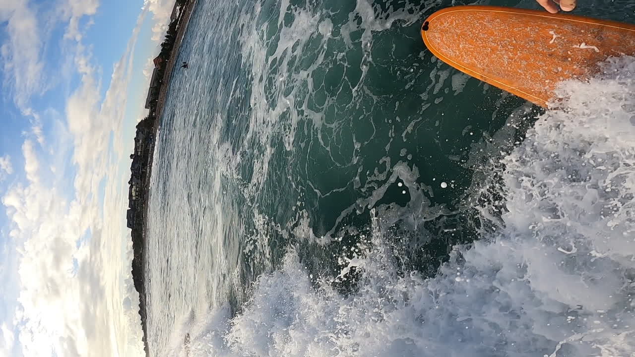 punto de vista vertical de surfista surfeando en una ola oceánica áspera en una tabla de espuma