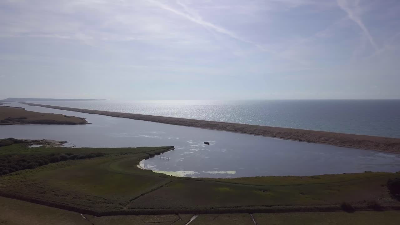 Ampio tracciato aereo in avanti verso la laguna della flotta all'estremità occidentale della spiaggia di ciottoli