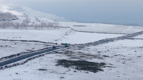 Luftdrohnenaufnahme-Eines-Lieferwagens-Und-Autos,-Die-Durch-Verschneite-Yorkshire-Täler-Fahren