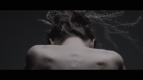 a woman dressed as mother nature moves slowly in a dance-like motion