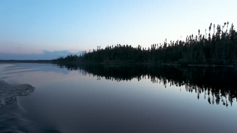 quiet fishing boat ride on a reflecting lake at sunset