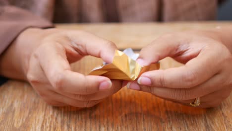 woman unwrapping a chocolate bar at a table