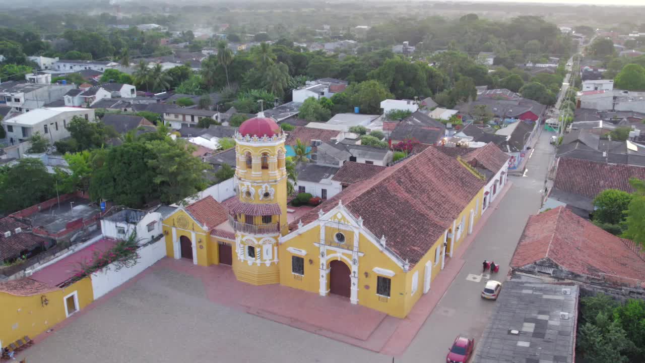 The streets, lined with whitewashed buildings and red-tiled roofs, take on a rich, amber hue, while the iconic churches and balconies seem to shine in the soft light.