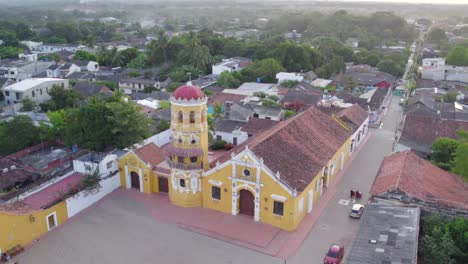the streets, lined with whitewashed buildings and red-tiled roofs, take on a rich, amber hue, while the iconic churches and balconies seem to shine in the soft light.