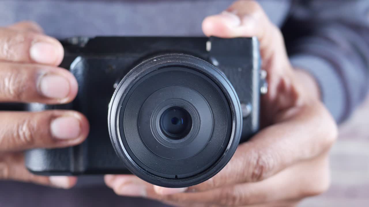 디지털 카메라를 들고 있는 사람