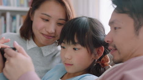 Familia-Asiática-Feliz-Usando-Tableta-Niña-Viendo-Entretenimiento-Con-Padres-Jugando-En-Un-Dispositivo-De-Pantalla-Táctil-Navegando-En-Línea-Relajándose-En-El-Sofá-Juntos-En-Casa-Imágenes-De-4k