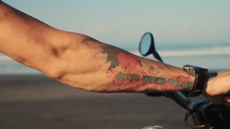 hombre montando una motocicleta en una playa al atardecer
