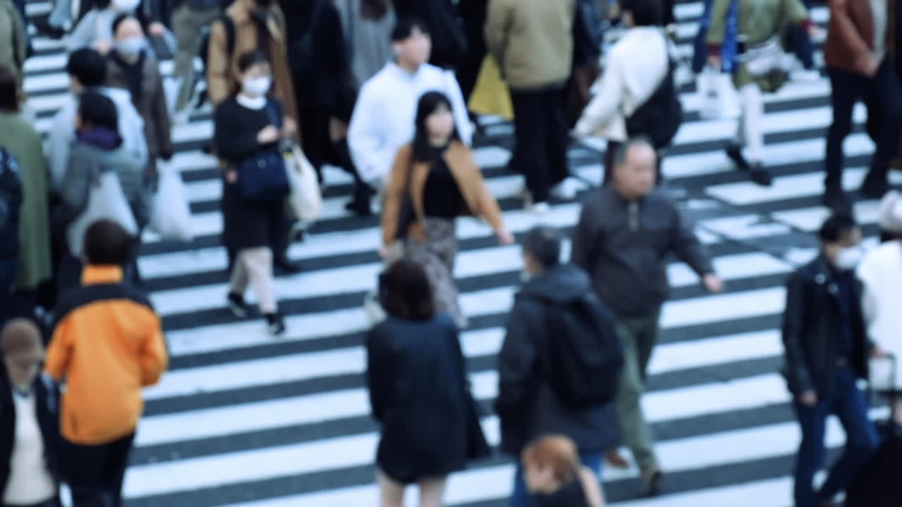 Blurred view crowd of people on the street of Shibuya scramble to cross. Slow Motion.