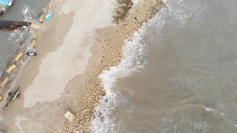 aerial top down shot of small waves hitting the sand in marsaxlokk malta