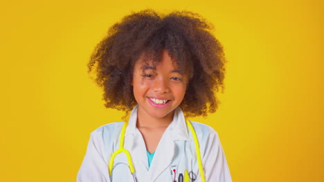 studio portrait of boy dressed as doctor or surgeon against yellow background