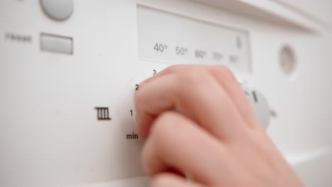 person adjusts time knob for temperature, close up view