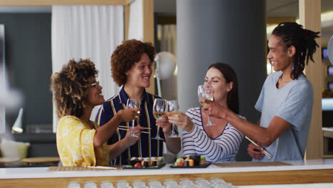 diverse group of happy friends raising glasses making a toast at a bar