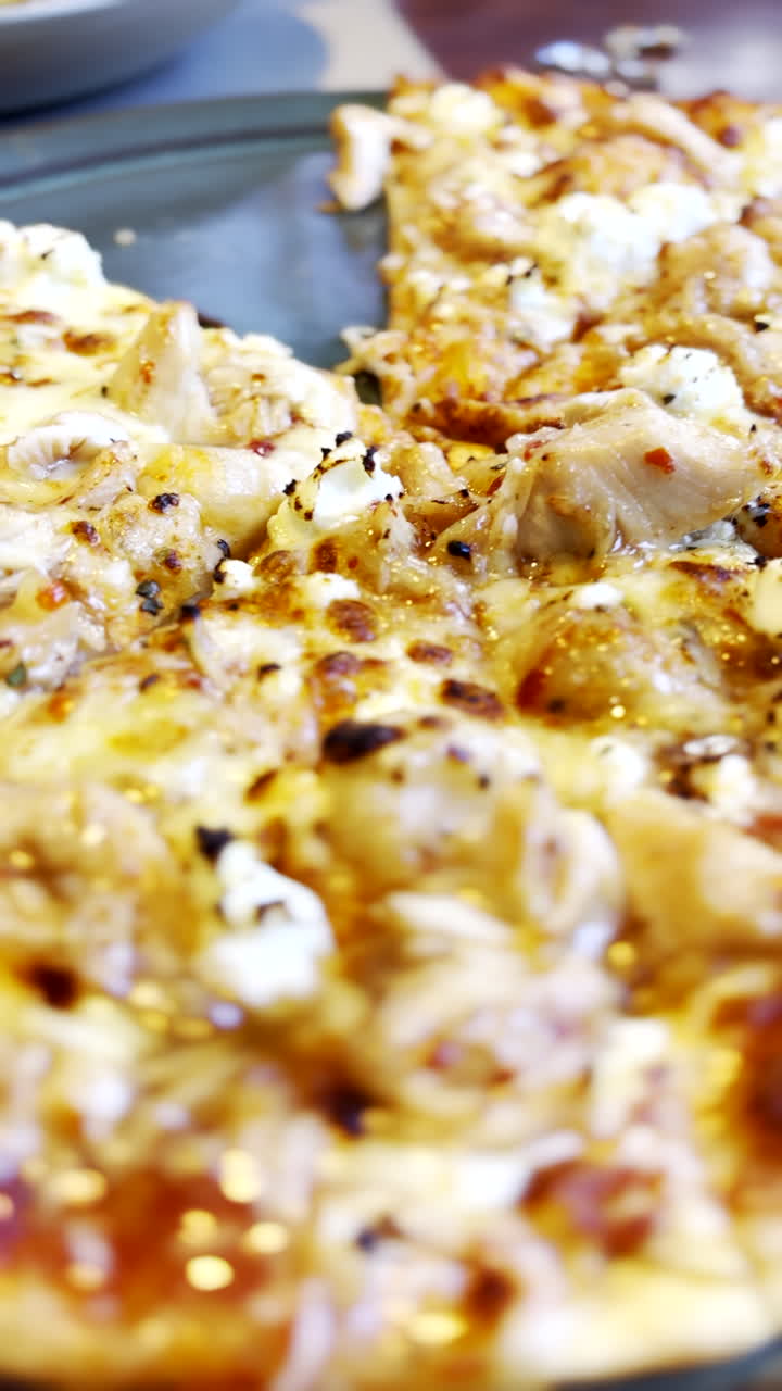 Pizza cremosa al formaggio al ristorante, cosparsa di Parmigiano Reggiano. Verticale