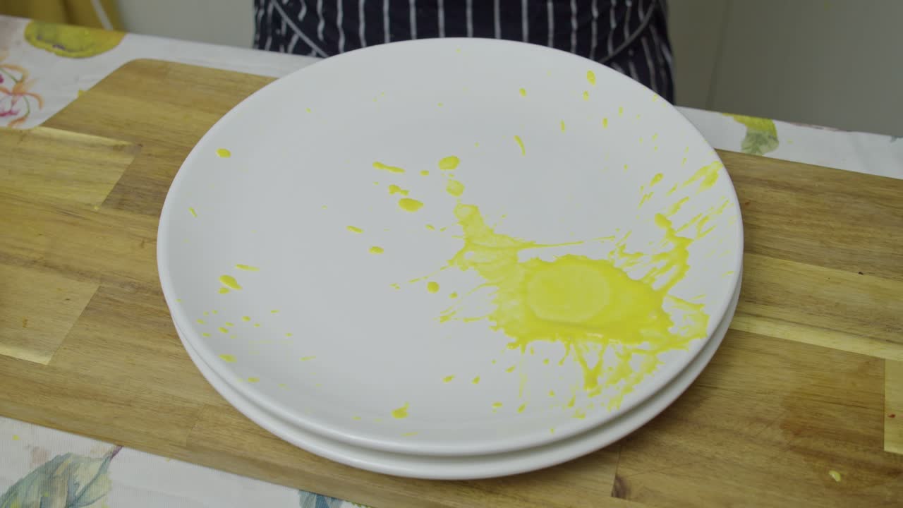 Chef vierte salsas coloridas sobre plato blanco