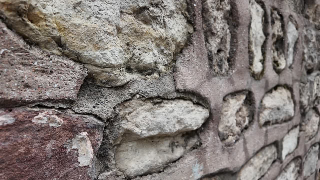 Vista dettagliata di un vecchio muro di pietra con texture ruvida.