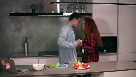 Young-caucasian-couple-in-casual-is-dancing-in-kitchen,-having-fun,-happy-together,-spending-morning-weekend-at-home.-Man-is