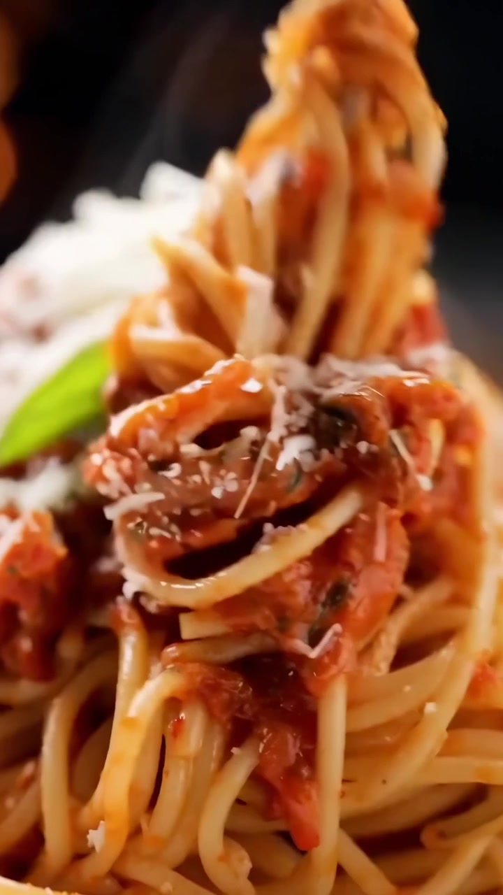 Spaghetti fumanti con ricco sugo di pomodoro e parmigiano grattugiato