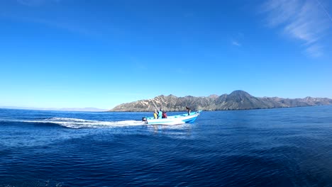 la toma de seguimiento de la cámara de acción sigue a los barcos de pesca, bahía asunción baja méxico a la vista.