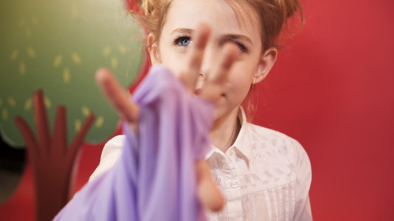Funny little girl with red hair posing in studio. Emotions of the child. Studio shooting of children.