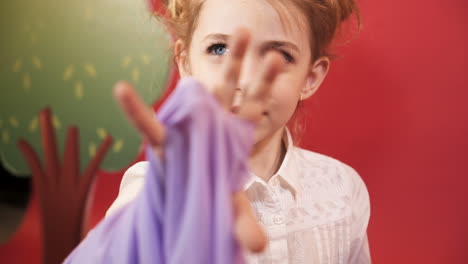 funny little girl with red hair posing in studio. emotions of the child. studio shooting of children.