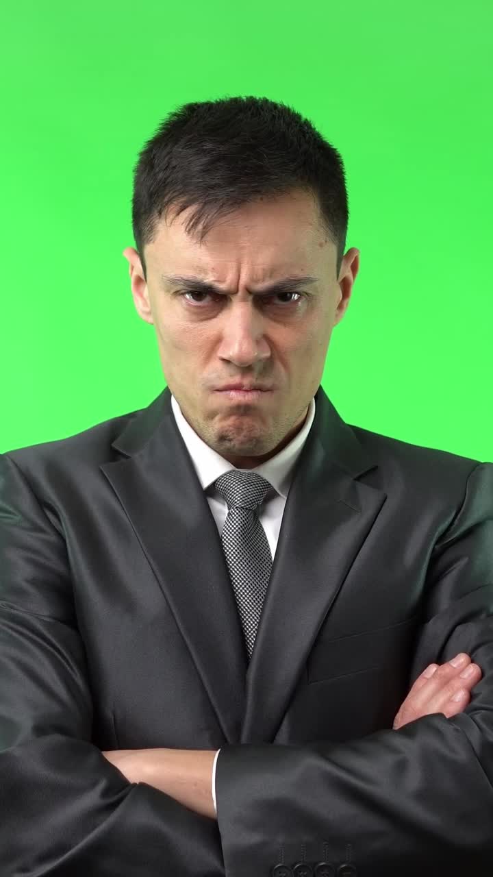 Angry Man in Suit on Green Screen with Arms Crossed